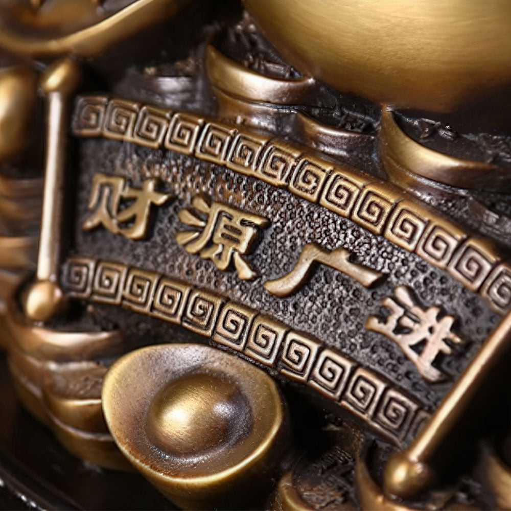 Gros plan sur l'inscription du crapaud porte-bonheur chinois en cuivre.