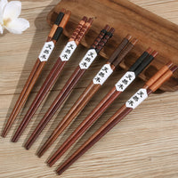 Thumbnail for Collection de six paires de baguettes chinoises réutilisables en bois, posées sur un plateau.