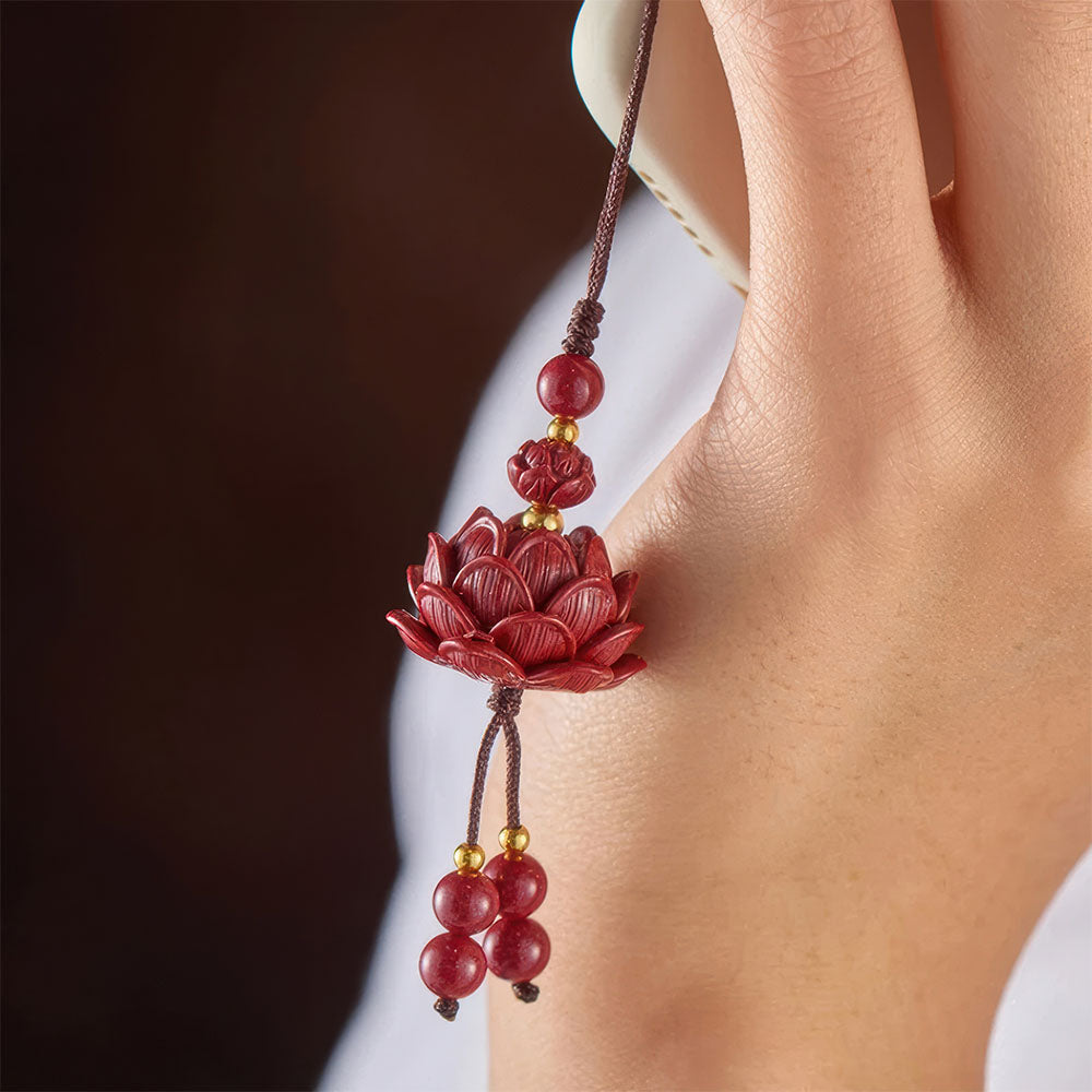 La fleur porte-bonheur chinoise, un pendentif en forme de lotus sculpté dans le cinabre.