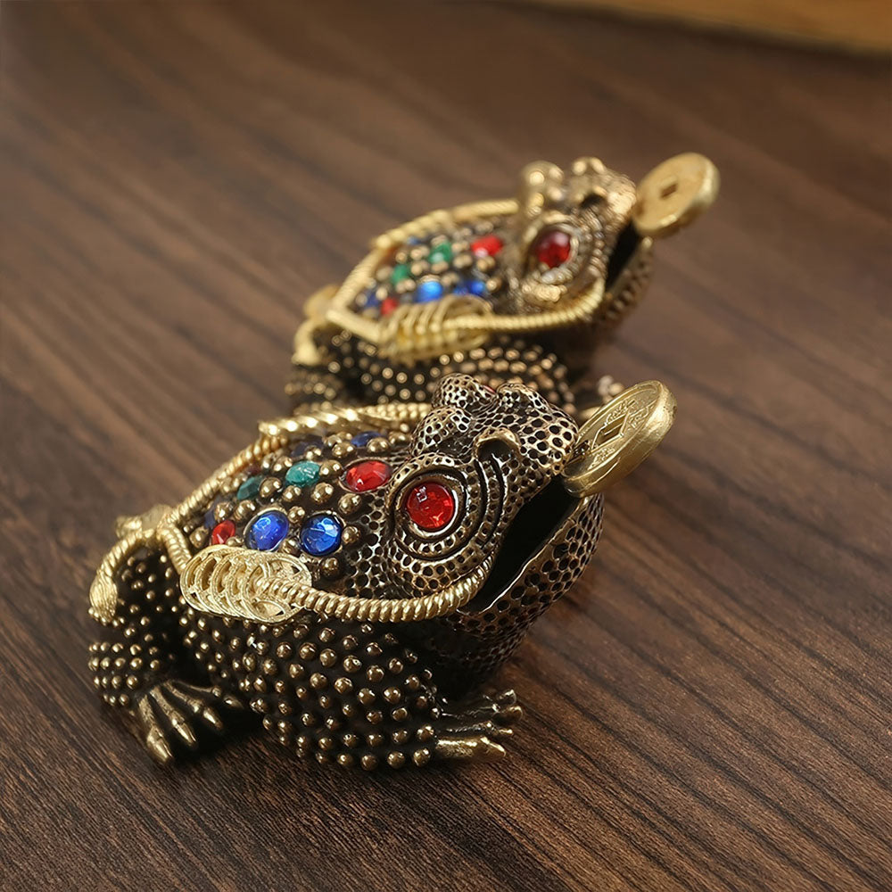 Gros plan sur le grand modèle de la grenouille porte-bonheur, montrant la sapèque dans sa bouche.
