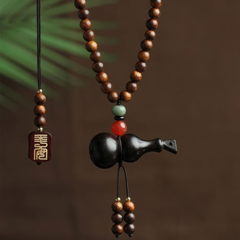 La variante en bois noir du porte-bonheur chinois avec sa gourde sculptée.