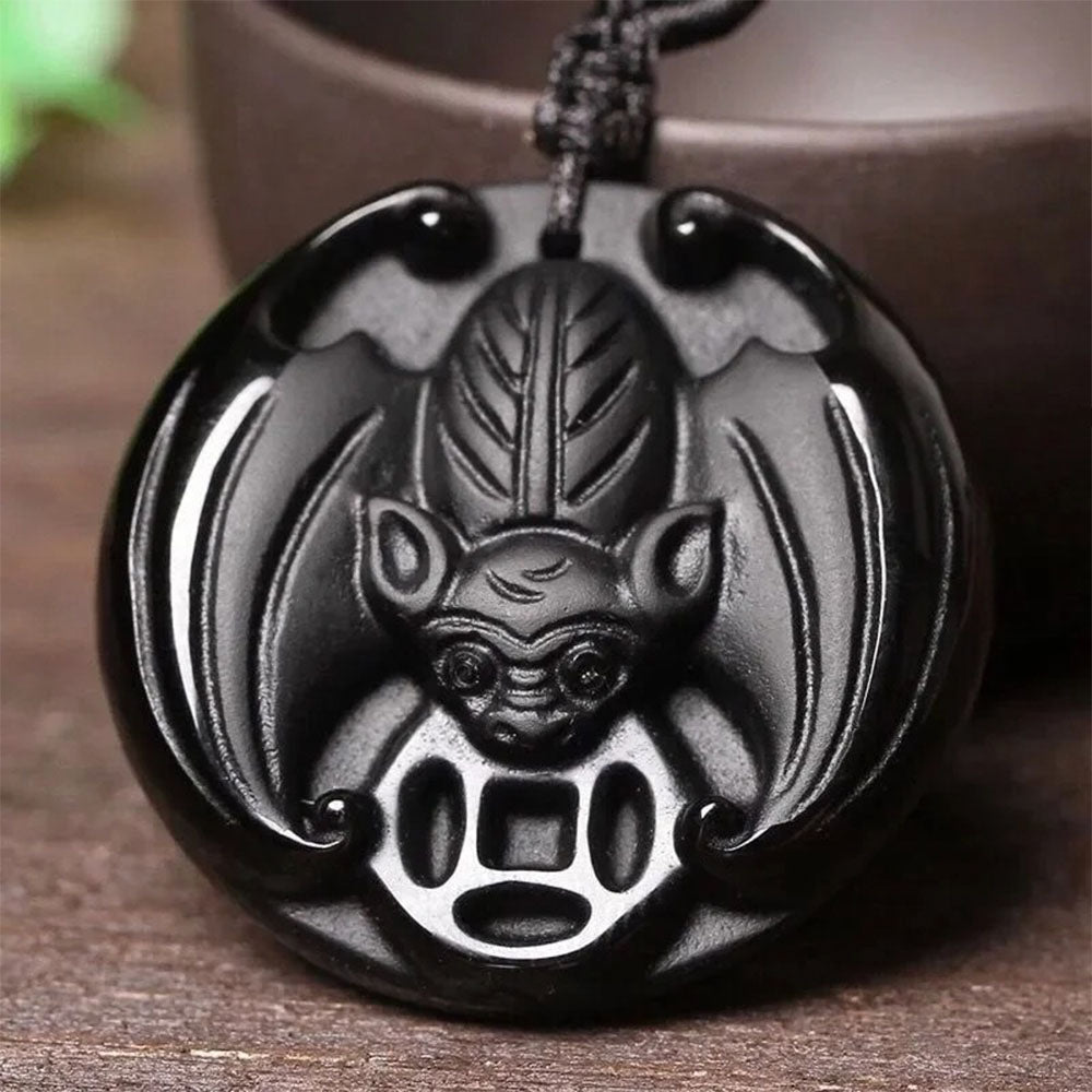 Le porte-bonheur chinois en forme de chauve-souris, sculpté dans l'obsidienne noire.