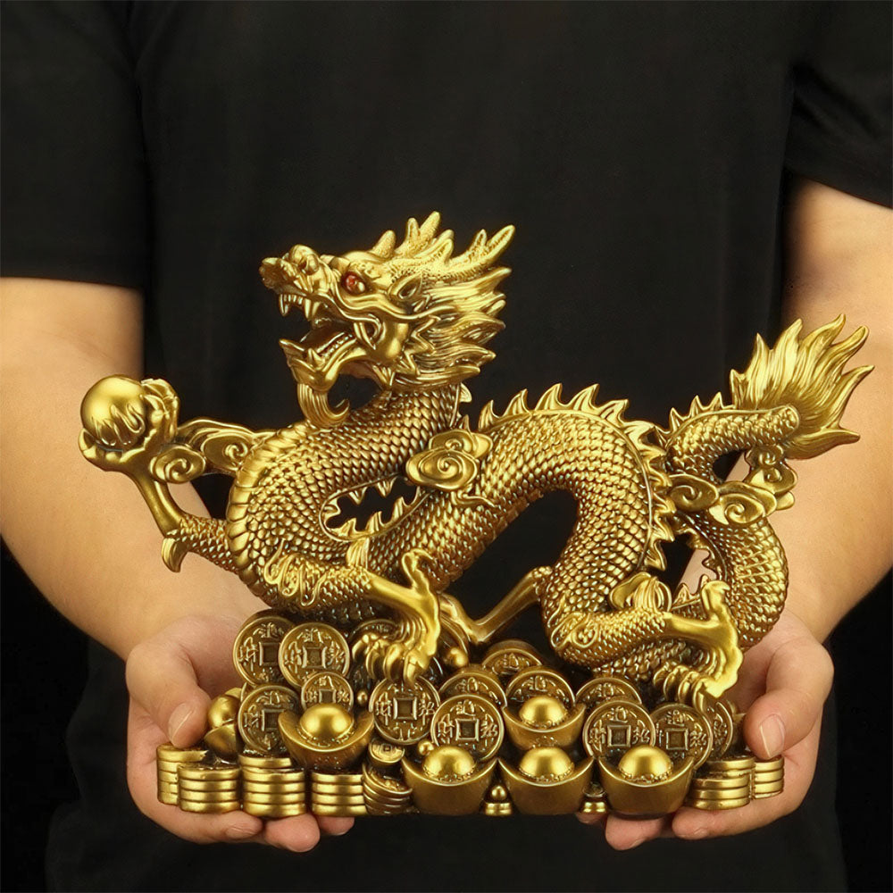 La statue porte-bonheur du dragon chinois en cuivre, tenue en main pour montrer sa taille imposante.