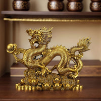 Thumbnail for Le porte-bonheur dragon en cuivre, utilisé comme décoration Feng Shui sur une étagère en bois.