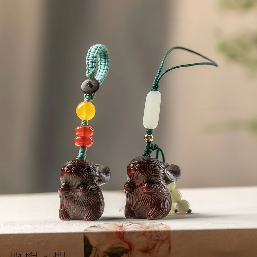 Les deux variantes du porte-bonheur lapin en bois de santal foncé, ornées de perles de jade.