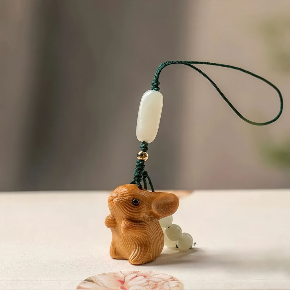 Le porte-bonheur lapin en bois clair avec son cordon simple et ses perles de jade blanc.