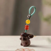 Thumbnail for Le porte-bonheur lapin en bois foncé avec sa boucle tressée et ses perles colorées.