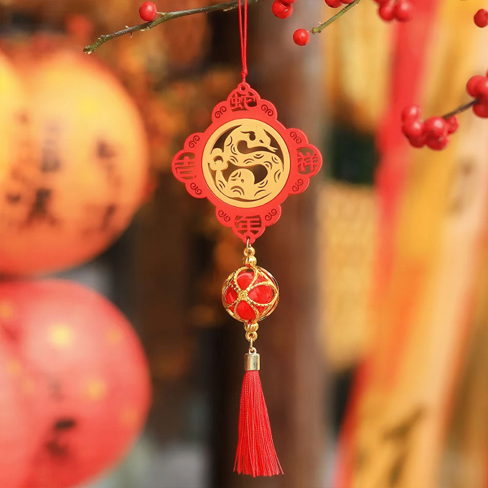 Pendentif avec un serpent protégeant une perle.