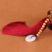 Thumbnail for Détail du pompon avec son chapelet de perles et son disque de jade.