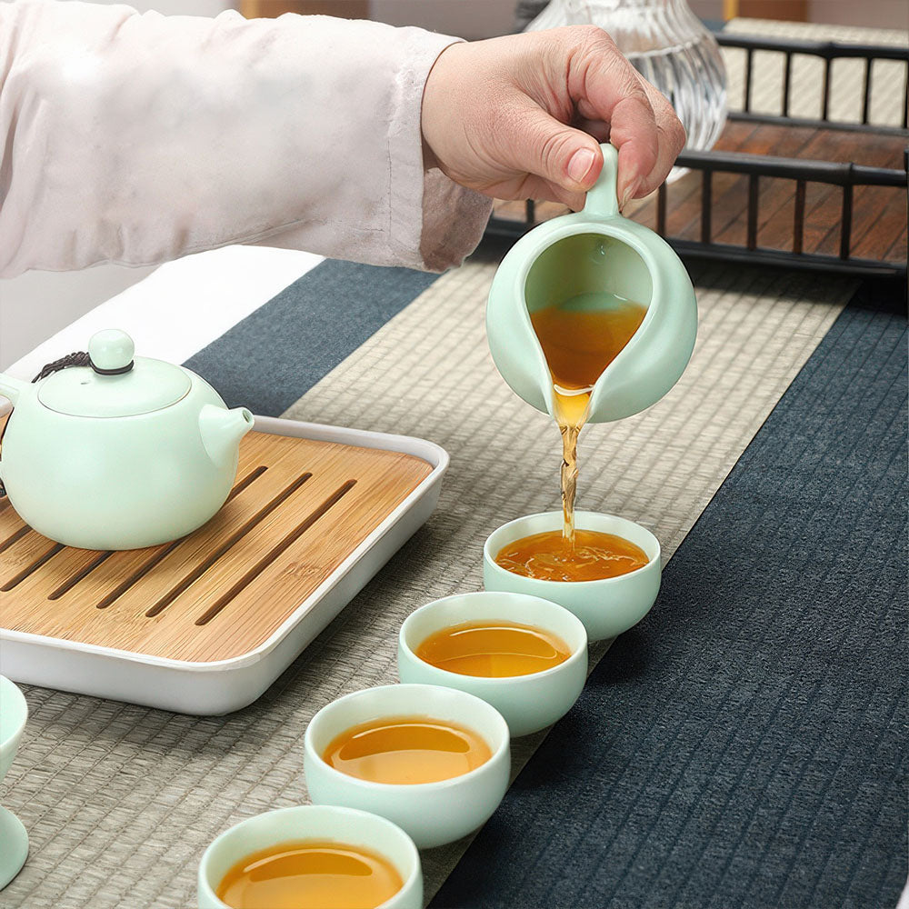 Gros plan sur les tasses se remplissant d'un thé ambré, mettant en valeur la couleur céladon.