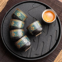 Thumbnail for Set de tasses chinoises en porcelaine dorée disposé sur un plateau à thé noir